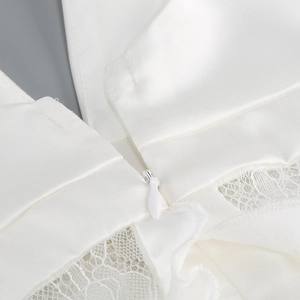 Detail of white satin dress featuring intricate lace trim and invisible zipper closure