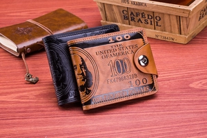 Detail of bifold wallets with 100 dollar bill pattern on brown and black faux leather