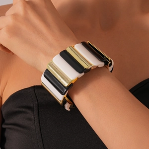 Detail of chunky acrylic elastic bracelet with black white and gold geometric links