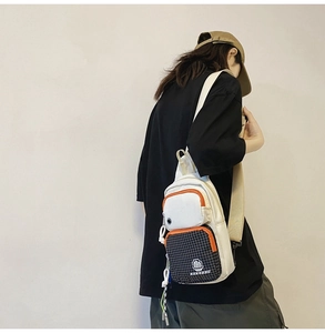 Side view of a white canvas chest bag with orange trim and checkered front pocket