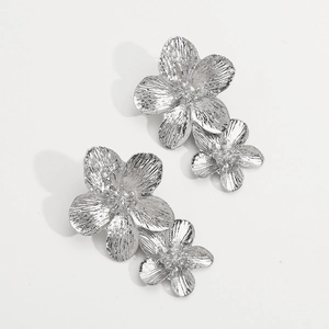 Detail of silver metallic double flower earrings with a layered 3D floral design