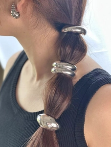 Detail of elegant silver metal hair band and matching textured hoop earrings set