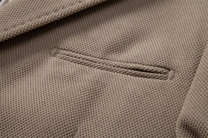 Vue macro du blazer en maille kaki montrant la précision des coutures et du tissu