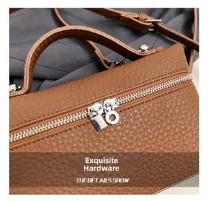 Detail of brown litchi pattern leather bag with silver metal zipper and hardware