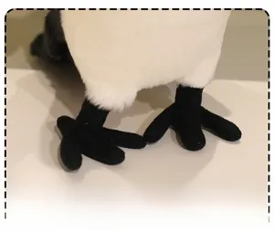 Close-up of fine plush fabric and detailed black claw stitching on magpie bird toy