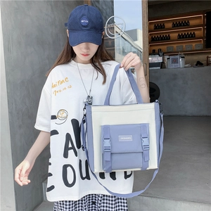 Detail of canvas tote bag with contrast panels and adjustable shoulder strap in casual setting