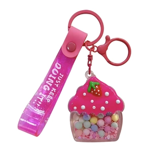 Cute pink cupcake keychain featuring oil-filled pastel beads and a glittery wrist strap