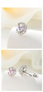 Macro shot of silver crescent moon earring with purple heart zircon and star details