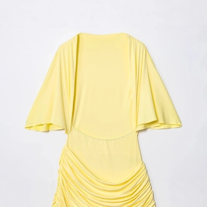 Elegant light yellow backless maxi dress with draped sleeves and pleated details