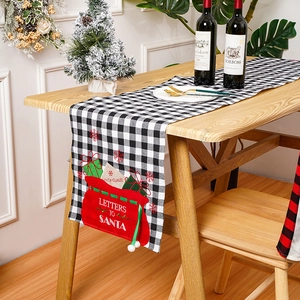 Detailweergave van ruitjes tafelloper met borduursel van de brievenzak van de kerstman.