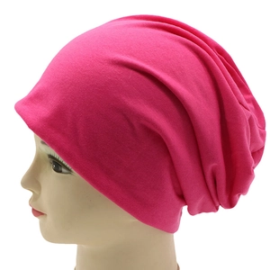 Close-up of rose red knitted slouchy beanie on a mannequin head with side view details