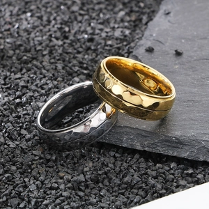 Close-up of gold and silver hammered texture rings on dark slate background