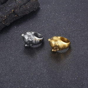 Polished stainless steel panda shaped rings in gold and silver colors on black surface