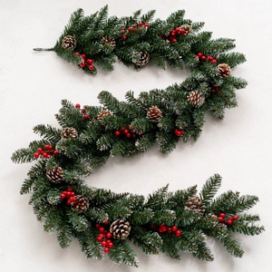 Lush Christmas garland with pine needles, pinecones, and red berries on marble background