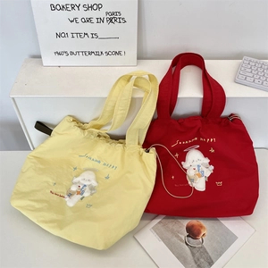 Detail of canvas tote bags with cute embroidered alpaca design and drawstring closure