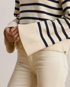 Close-up of thick striped knit texture and wide cuff detail on a cream and navy sweater