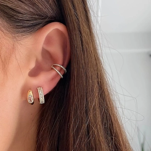 Close-up of gold square-cut gemstone hoop and pavé diamond earrings with ear cuff