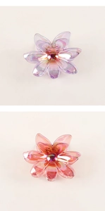 Macro detail of translucent iridescent flower hair clips in purple and orange-pink colors