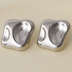 Detail of silver irregular geometric bean studs with polished stainless steel surface
