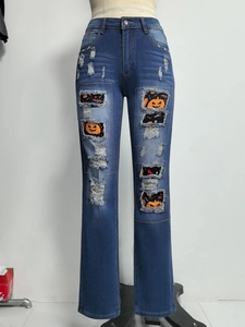 Detail der blauen Jeans mit Halloween-Print-Patches in den destroyed Rissen des Stoffs