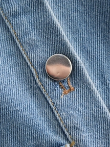 Gros plan détaillé du tissu denim bleu avec bouton en métal argenté et coutures précises