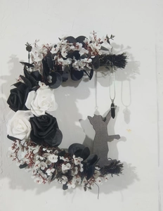 Macro detail of crescent moon wreath with black roses, cat silhouette and crystal pendant