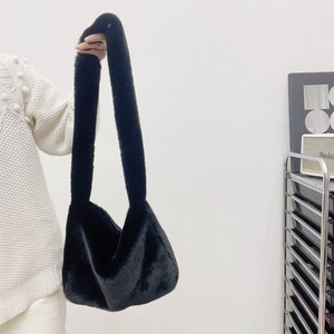 Detail of soft black faux fur tote bag showing the plush texture and wide shoulder strap