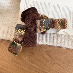 Macro shot of tweed bow hair claw clip with antique gold wire and resin base