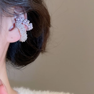 Close-up of purple pearl and clear crystal beaded ear cuffs worn on the left ear