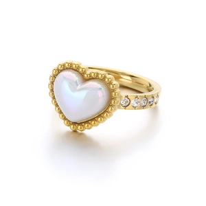 Golden heart ring with iridescent shell center and diamonds on a white background