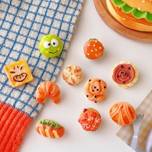 Flat lay macro of colorful resin mini burger, sandwich and bread charms for DIY crafts