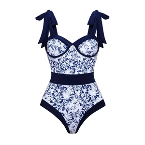 Detail of blue floral print swimsuit with contrasting trim and shoulder bow ties