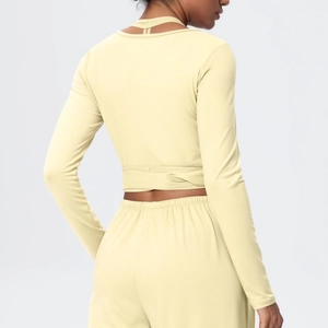 Back view of a cream yellow long sleeve cropped top and high waist yoga leggings set