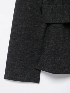Close-up of soft knitted fabric texture on the cuff and tie belt of a dark grey coat