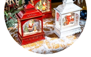 Classic red and white Christmas snow lanterns with Santa Claus figurines on a wooden table