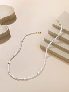Detail of irregular baroque pearl necklace with gold beads and adjustable lobster clasp