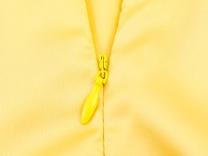 Detailed close-up of the high-quality invisible yellow zipper on smooth satin dress fabric
