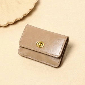 Nahaufnahme der braunen Lederbörse mit goldenem Drehverschluss und präzisen Nähten