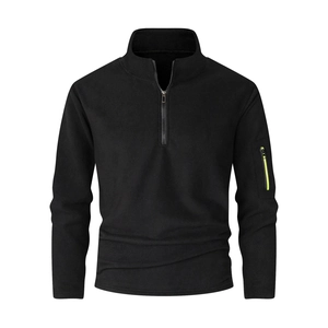 Detail of black fleece pullover showing the stand collar and neon yellow sleeve pocket zipper