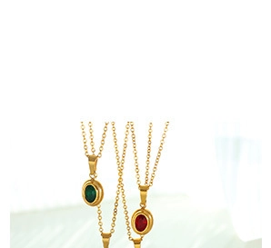 Détail de colliers dorés vintage avec pendentifs ovales en zircon rouge et vert