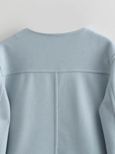 Macro shot of light blue tweed jacket back with detailed I-shaped stitching on the fabric