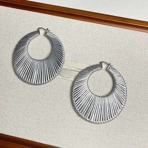 Détails de grandes boucles d'oreilles créoles argentées avec texture rainurée radiale