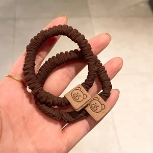 Cute brown bear scrunchies with square buckle details on hand for hair styling