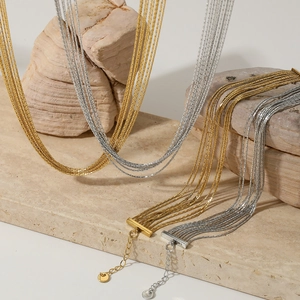 Multilayer tassel chain necklaces in gold and silver finish on natural stone background