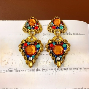 Detailed macro view of vintage gold earrings with amber gemstones on an open book