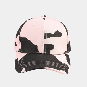 Detail of pink and black cow print baseball cap with durable cotton canvas texture