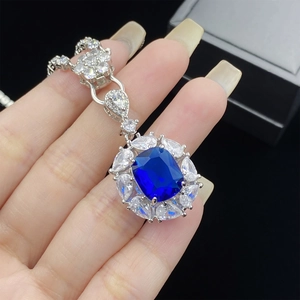 Detailed close-up of a blue gemstone necklace with rectangle cut and floral accents