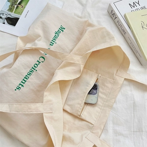 Close-up of internal zipper pocket in cream canvas tote bag with phone storage space