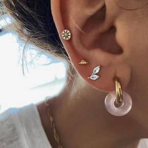 Macro shot of S925 silver marquise studs and gold pink hoop earrings on model ear