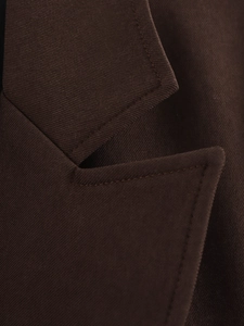 Macro shot of dark brown blazer lapel with double-stitched twill fabric texture